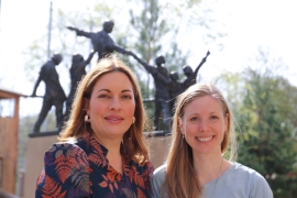 Julia Dahmen und Anna-Lena Koalick stehen lächelnd vor eine Statue von Don Bosco.