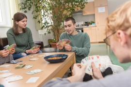 Jugendliche spielen an einem Tisch Karten