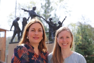 Julia Dahmen und Anna-Lena Koalick stehen lächelnd vor eine Statue von Don Bosco.
