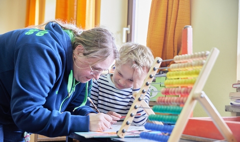 Erzieherin im Oratorium hilft Schüler bei den Hausaufgaben