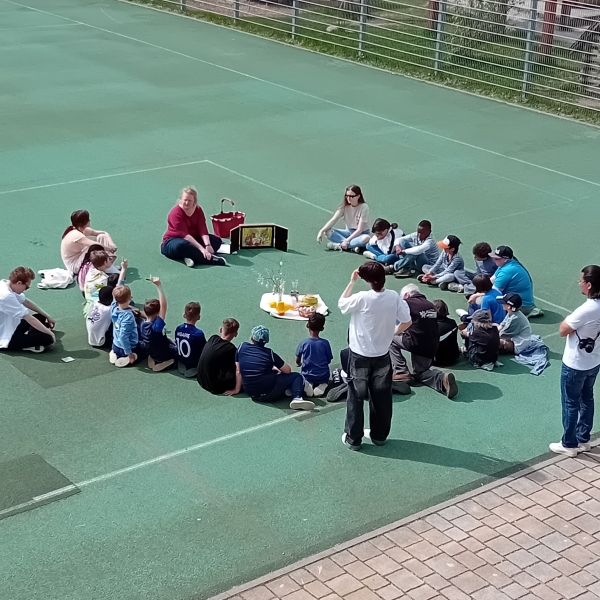 Erzählung der Ostergeschichte von Martina Edenhofer auf dem Sportplatz des Salesianums