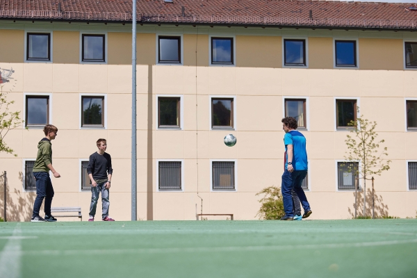 Jugendliche des Oratoriums spielen auf dem Platz Fußball