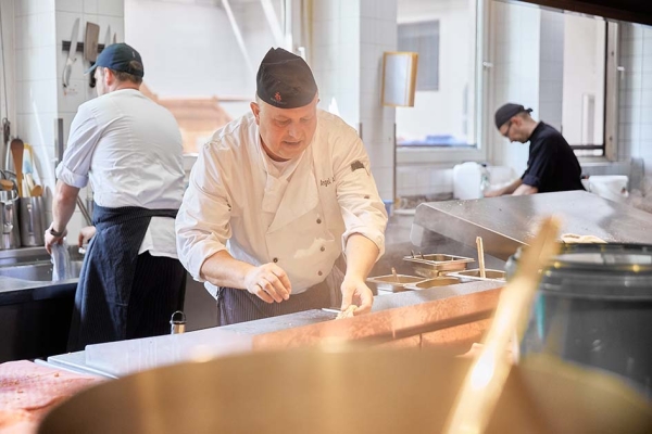 Koch bereitet in der Küche Essen zu