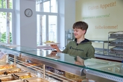 Jugendlicher an der Theke zur Essenausgabe