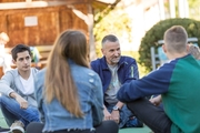 Junge Menschen mit Erzieher auf dem Sportplatz